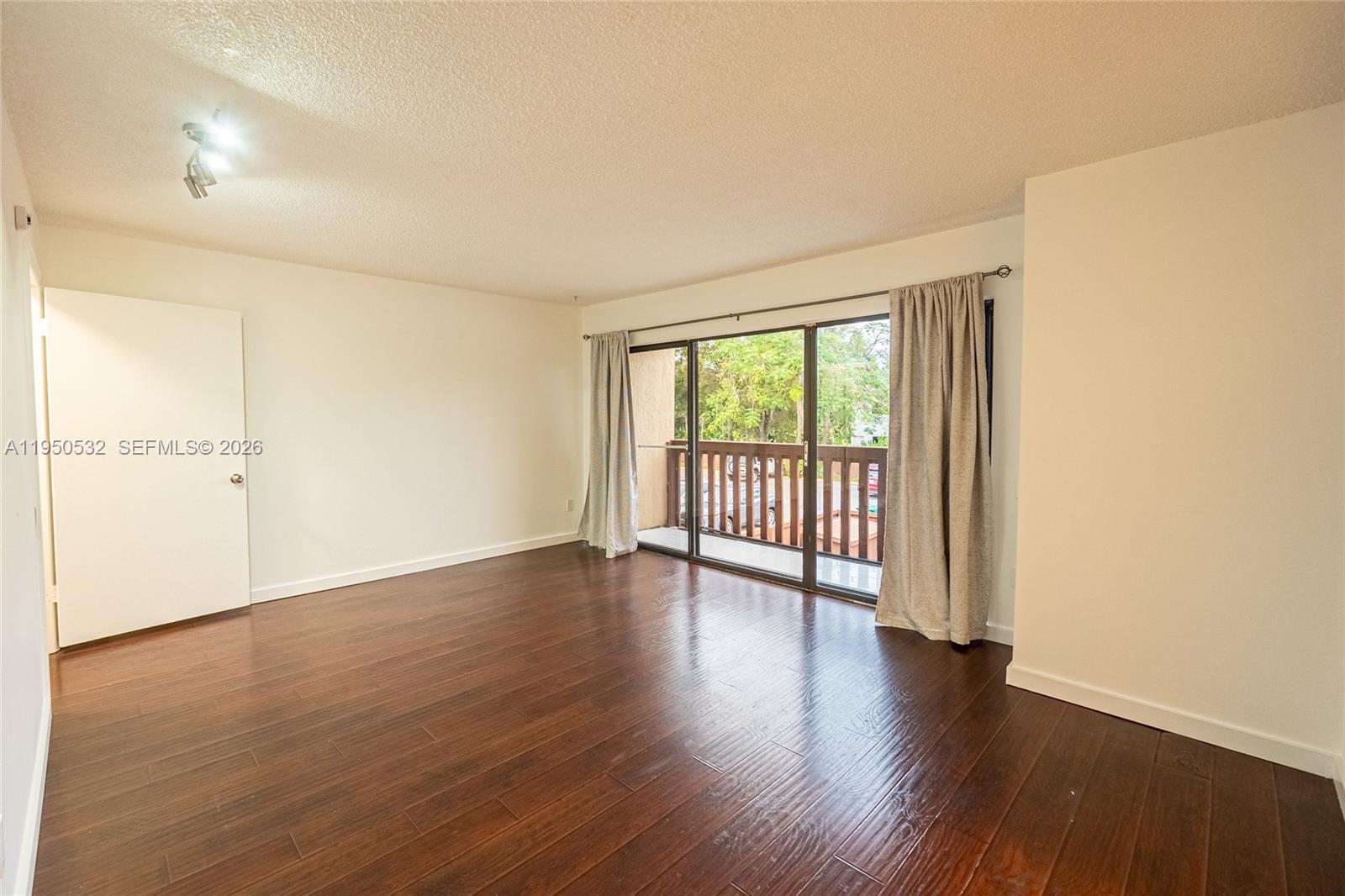 6534 Southwest 114th Place, Unit G75 Miami, FL 33173 - Photo 24 of 52 an empty room with wooden floor and windows