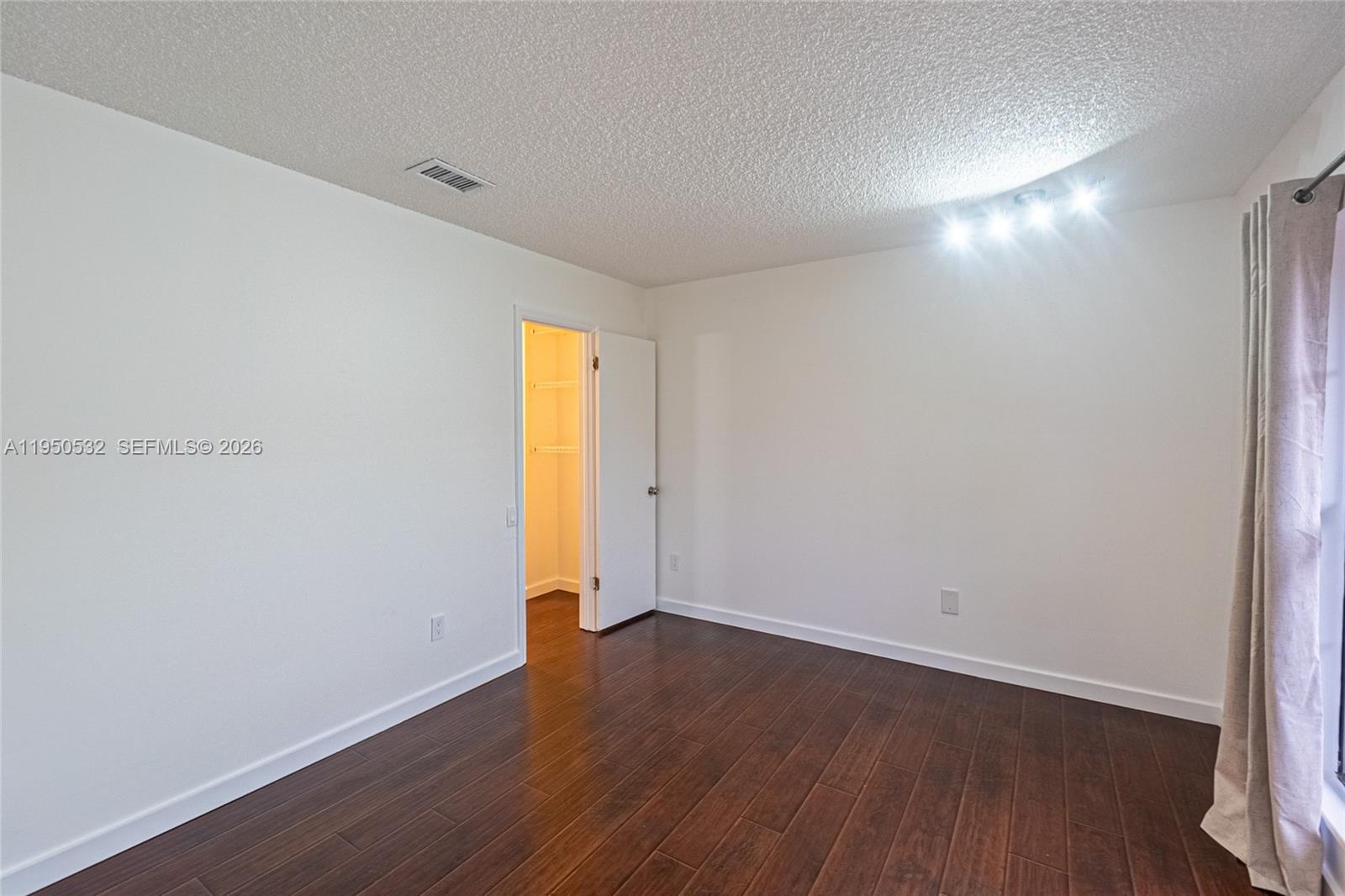 6534 Southwest 114th Place, Unit G75 Miami, FL 33173 - Photo 32 of 52 an empty room with wooden floor and window