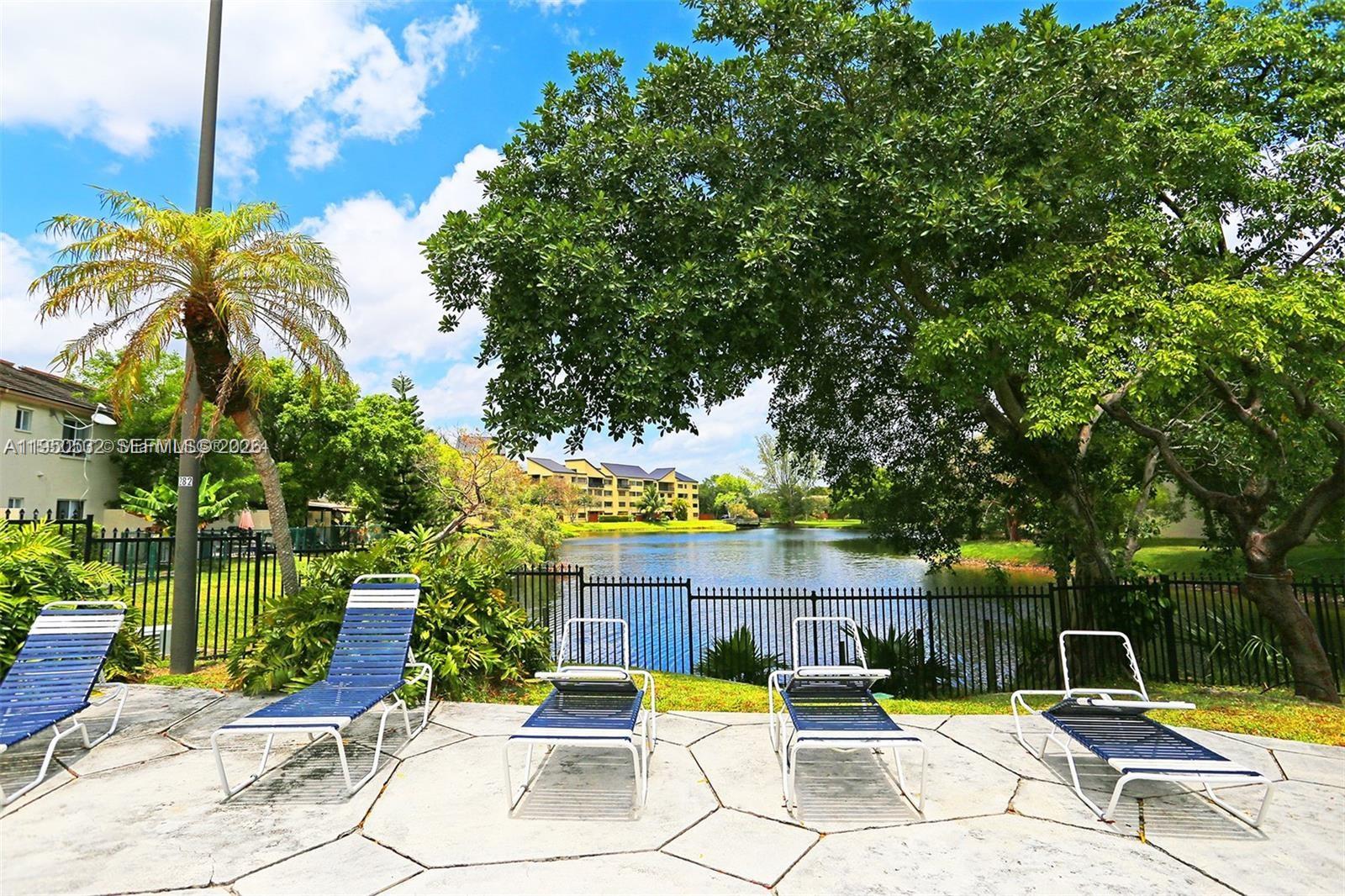 6534 Southwest 114th Place, Unit G75 Miami, FL 33173 - Photo 42 of 52 a view of swimming pool with seating space and trees in the background