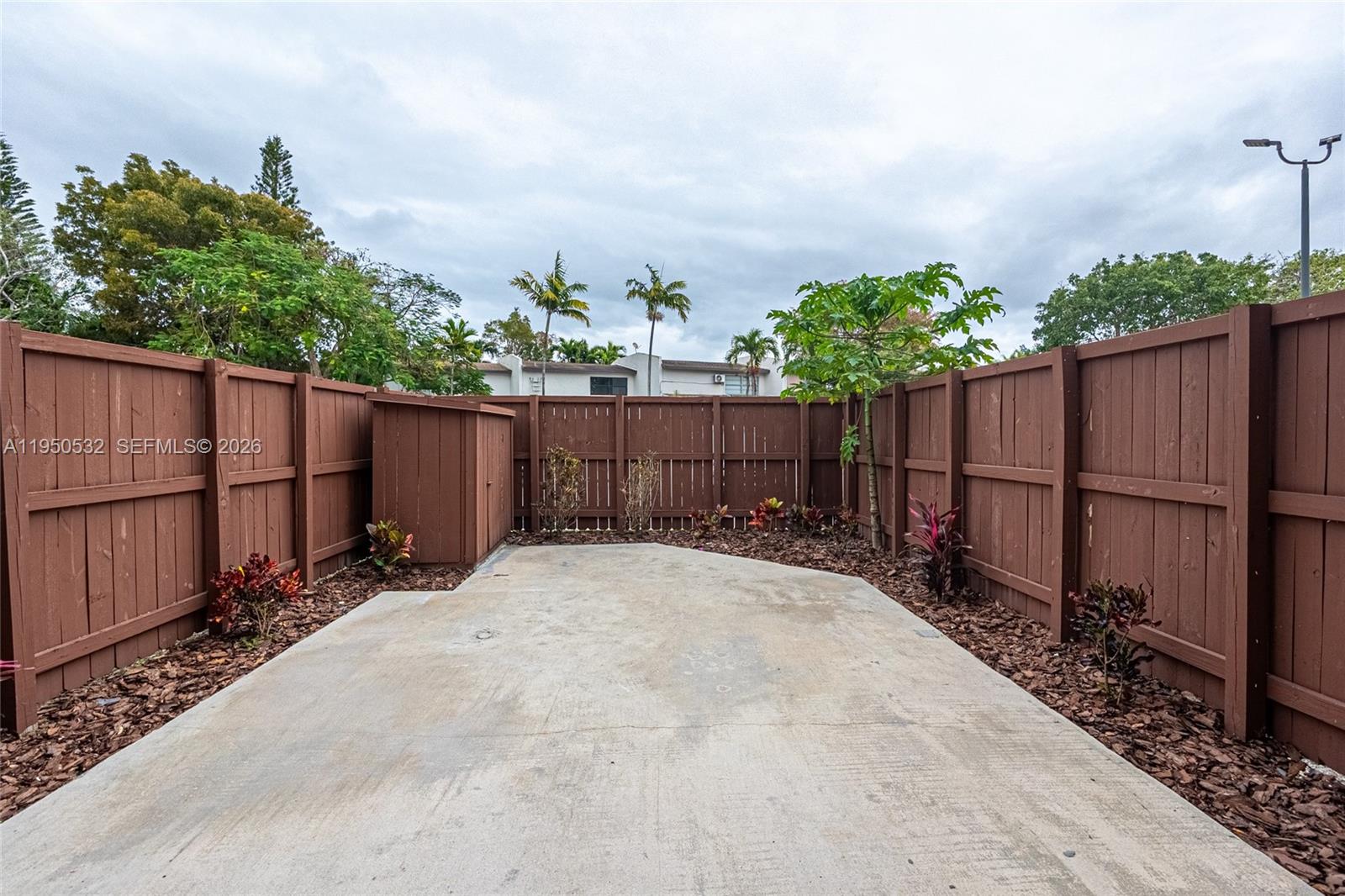 6534 Southwest 114th Place, Unit G75 Miami, FL 33173 - Photo 8 of 52 a couple of flower plants sitting in yard with wooden fence