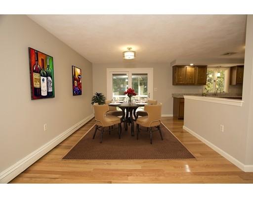 8 Rustic Lane Reading, MA 01867 - Photo 11 of 29 a living room with furniture a flat screen tv and kitchen view