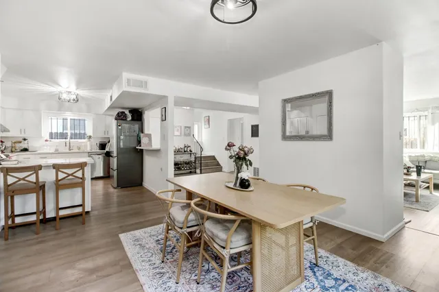 a kitchen with stainless steel appliances kitchen island a table and chairs in it