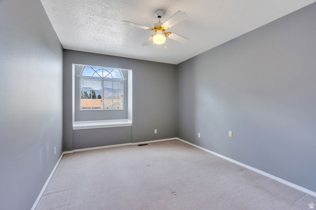 886 West 1700th Street North Mapleton, UT 84664 - Photo 12 of 21 Arch-top window with integrated window seat, ceiling fan with light fixture, light gray carpeting, and textured walls