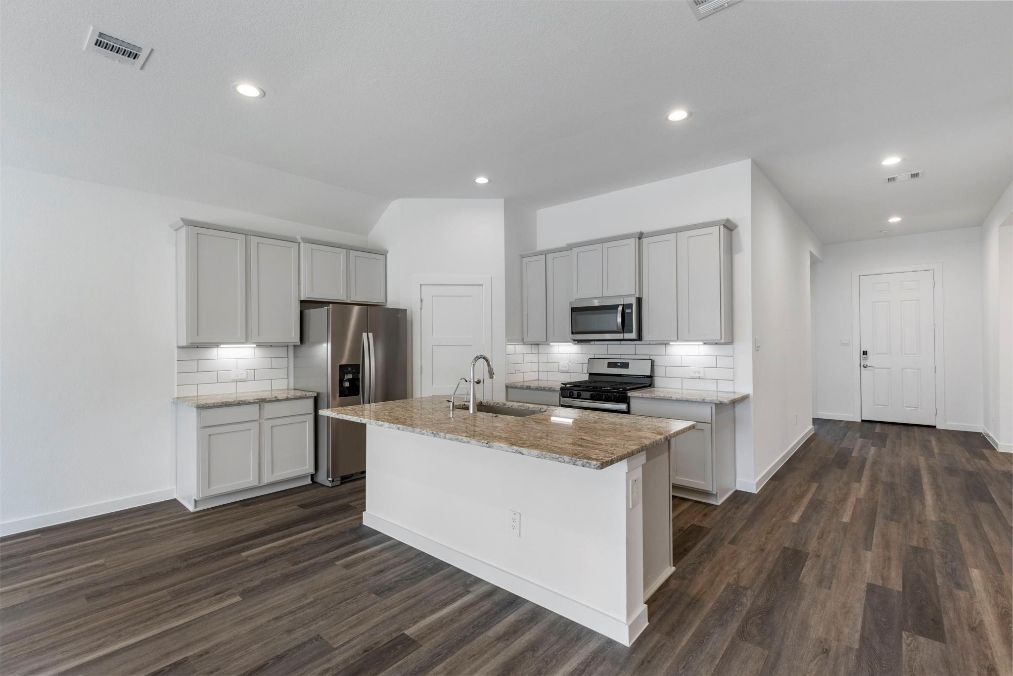 1644 Little Rabbit Court Montgomery, TX 77316 - Photo 13 of 27 a kitchen with granite countertop a sink cabinets stainless steel appliances and wooden floor