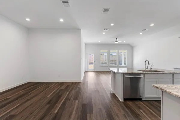 a kitchen with kitchen island wooden floors and stainless steel appliances