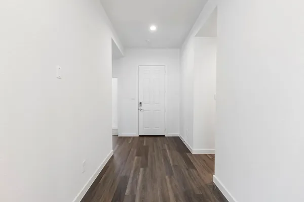 a view of a hallway with wooden floor