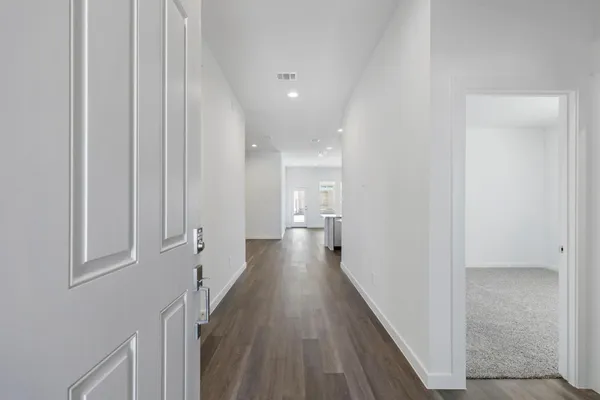 a view of a hallway with wooden floor and staircase