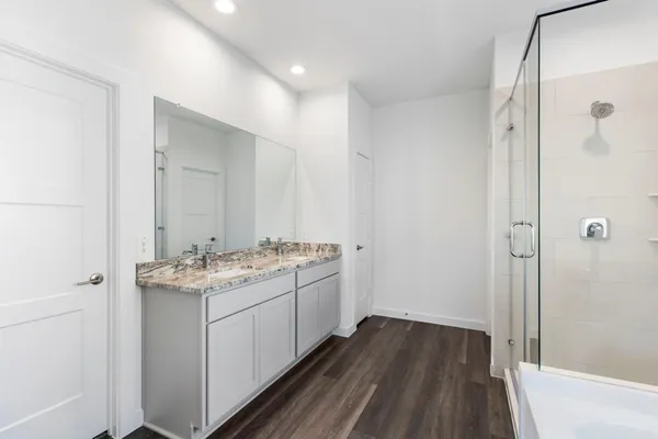 a bathroom with a sink and mirror with shower