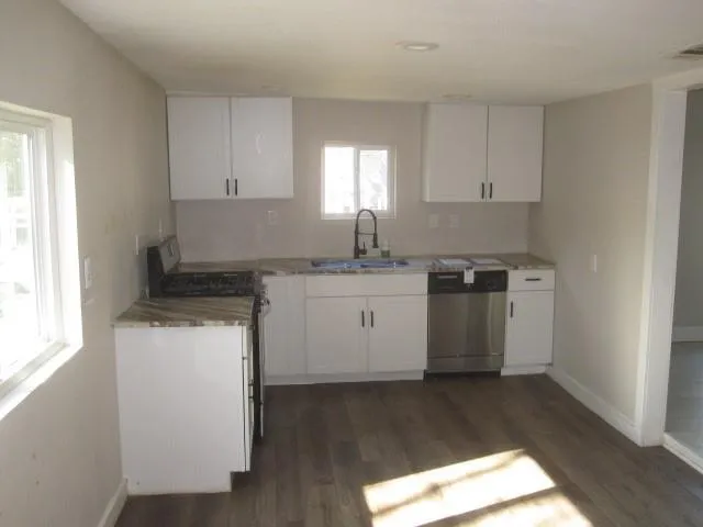a kitchen with a sink window and cabinets
