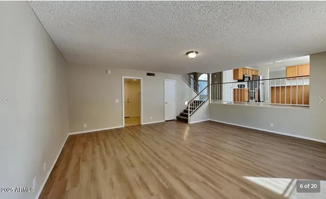 a view of empty room with wooden floor and stairs