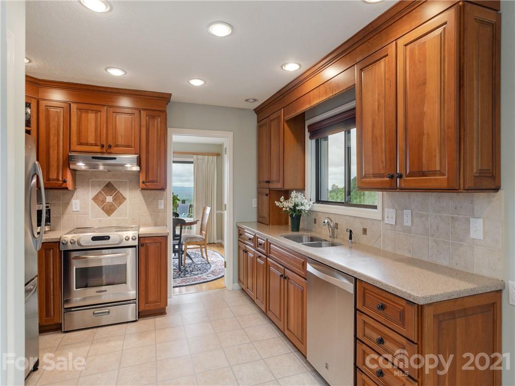 143 Country Ridge Road Hendersonville, NC 28739 - Photo 17 of 29 a kitchen with stainless steel appliances granite countertop a stove sink and cabinets