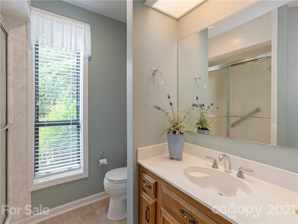 143 Country Ridge Road Hendersonville, NC 28739 - Photo 28 of 29 a bathroom with a granite countertop sink toilet and shower