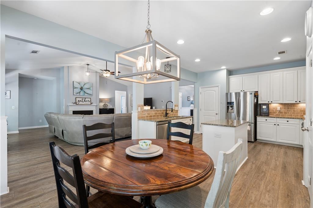 2467 Allsborough Way Dacula, GA 30019 - Photo 13 of 45 a living room with stainless steel appliances furniture a dining table and chairs