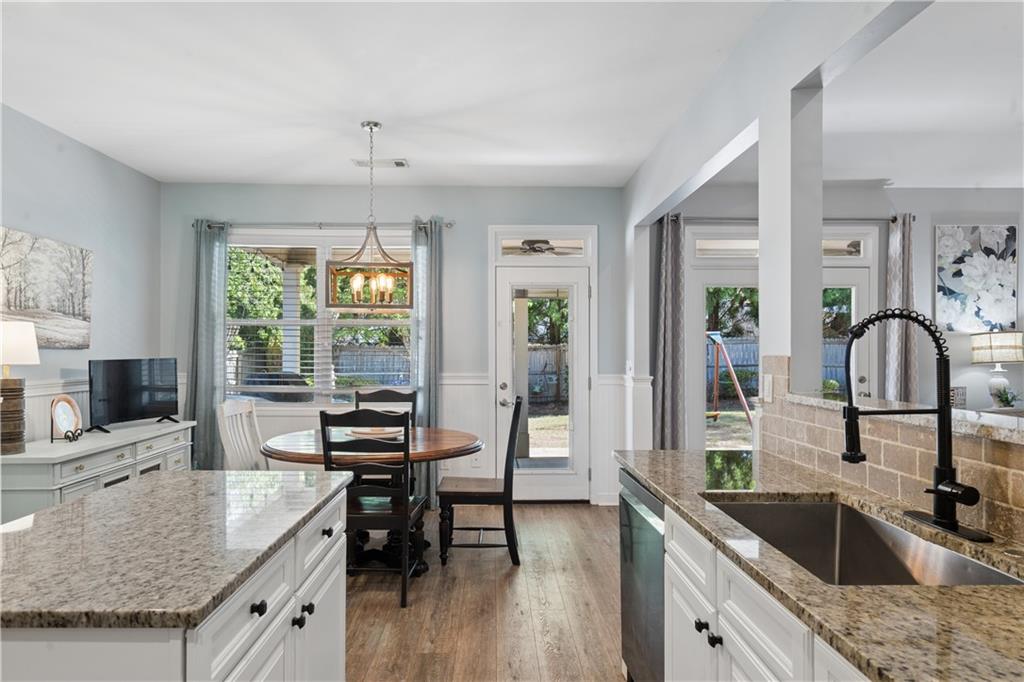 2467 Allsborough Way Dacula, GA 30019 - Photo 19 of 45 a kitchen with granite countertop a sink dining table and chairs