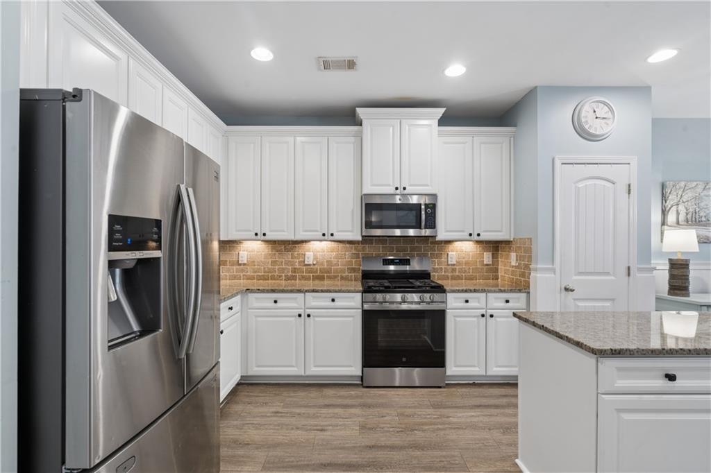 2467 Allsborough Way Dacula, GA 30019 - Photo 20 of 45 a kitchen with stainless steel appliances and white cabinets