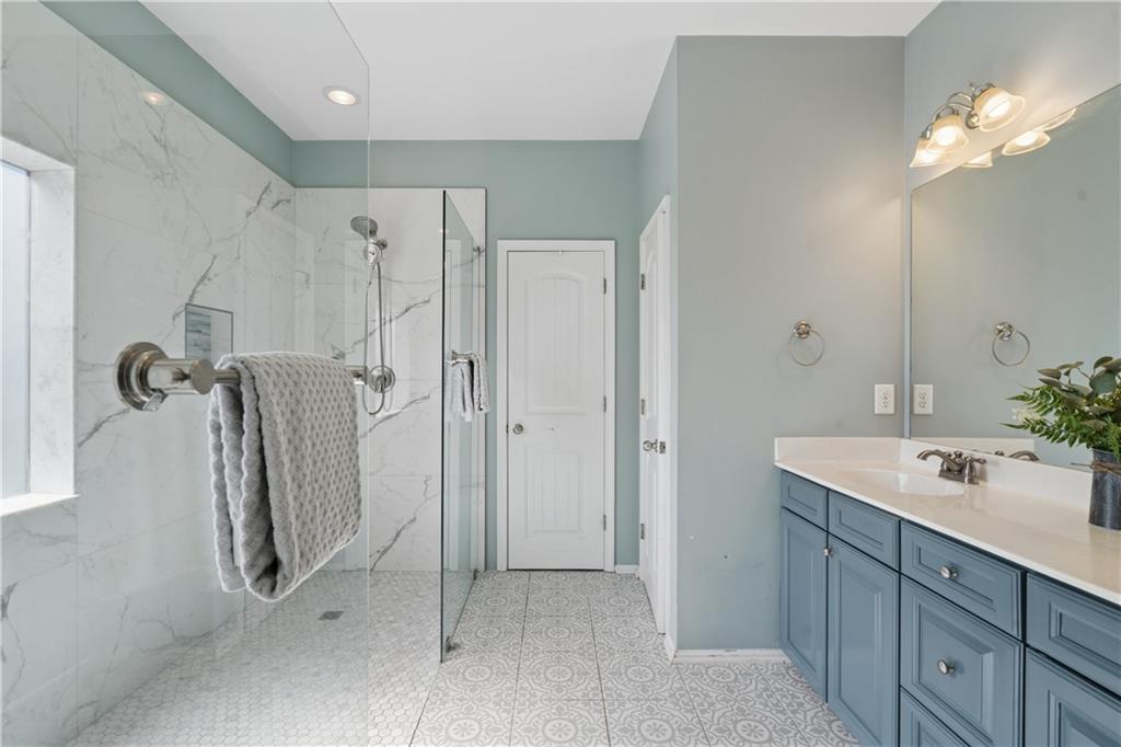 2467 Allsborough Way Dacula, GA 30019 - Photo 25 of 45 a bathroom with a double vanity sink a shower and a mirror