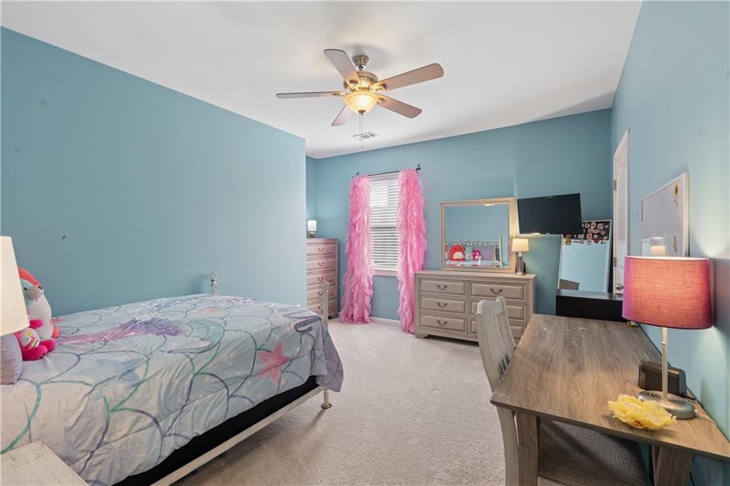 2467 Allsborough Way Dacula, GA 30019 - Photo 27 of 45 a bedroom with a bed and a chandelier