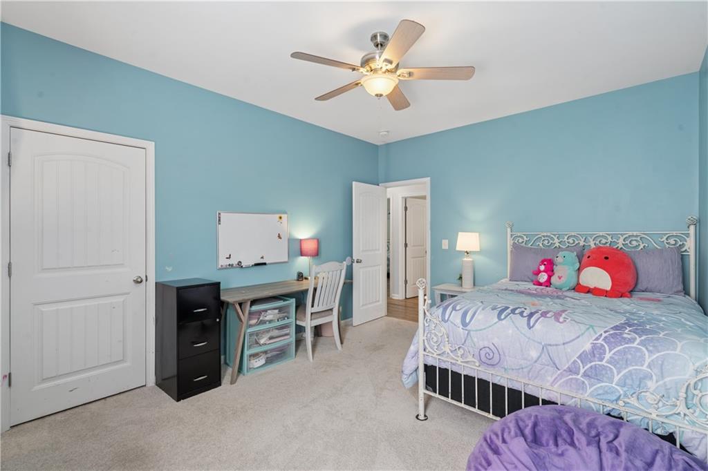 2467 Allsborough Way Dacula, GA 30019 - Photo 28 of 45 a bedroom with a bed and a chandelier