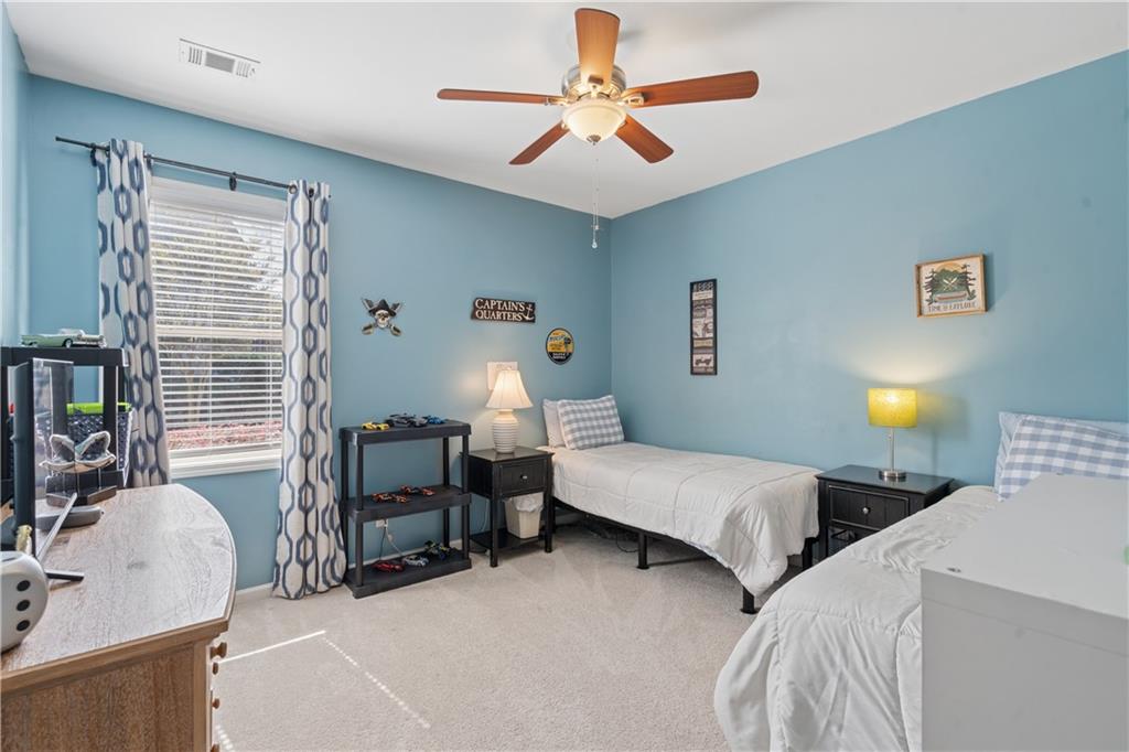 2467 Allsborough Way Dacula, GA 30019 - Photo 32 of 45 a bedroom with a bed and a chandelier