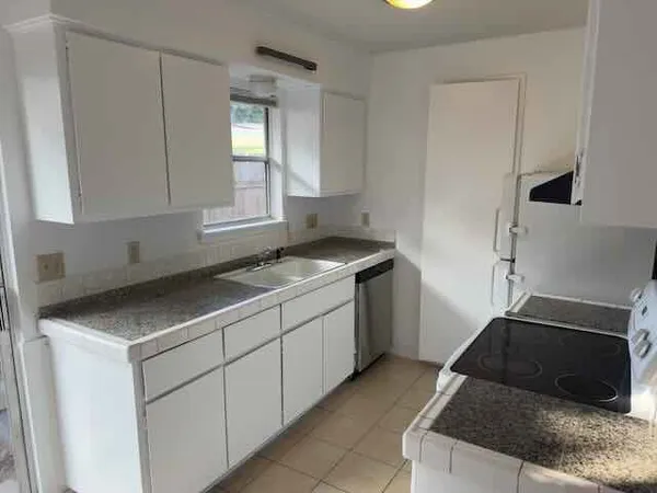 a kitchen that has a sink and a stove in it