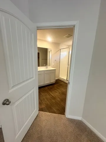 a view of a room that has a large window and a kitchen view