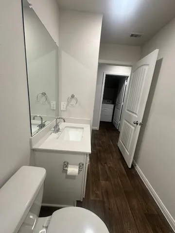 a bathroom with a sink a toilet a mirror and vanity