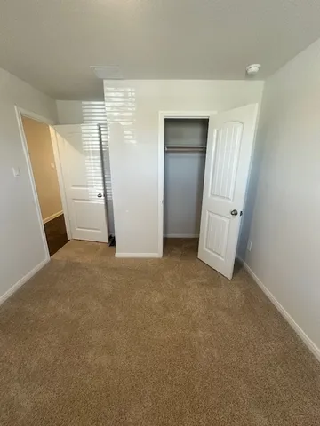 an empty room with closet and mirror