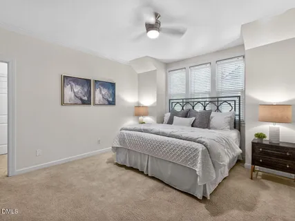 a spacious bedroom with a bed and a chandelier