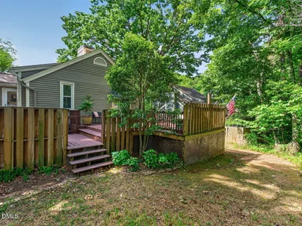 a view of backyard with wooden fence and a large tree