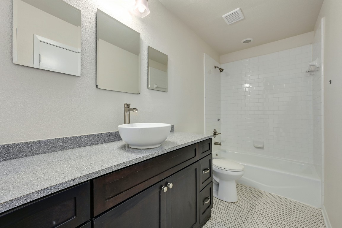 1709 Ulit Avenue Austin, TX 78702 - Photo 10 of 20 a bathroom with a granite countertop sink a toilet and bathtub