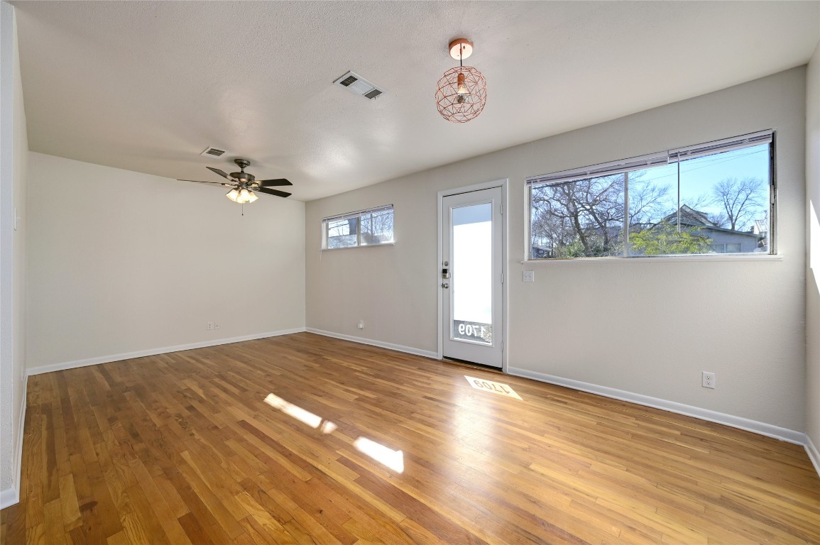 1709 Ulit Avenue Austin, TX 78702 - Photo 3 of 20 wooden floor in an empty room with a window