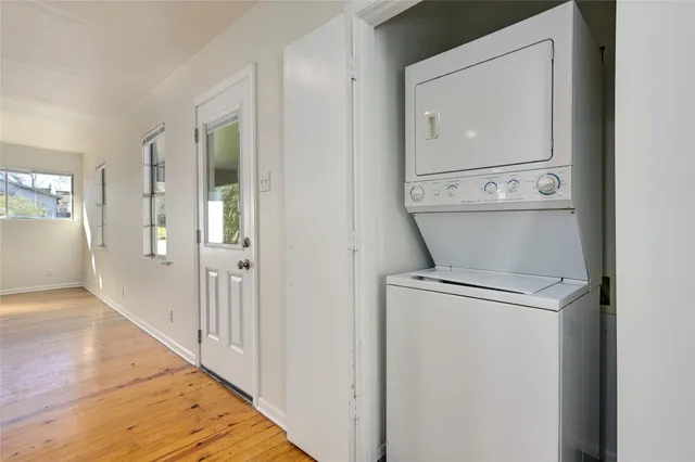 a view of empty room with wooden floor and windows