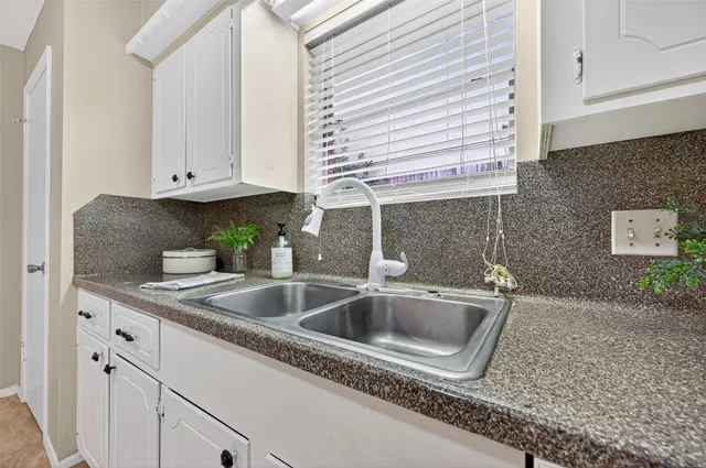 a kitchen with granite countertop a sink and a stove