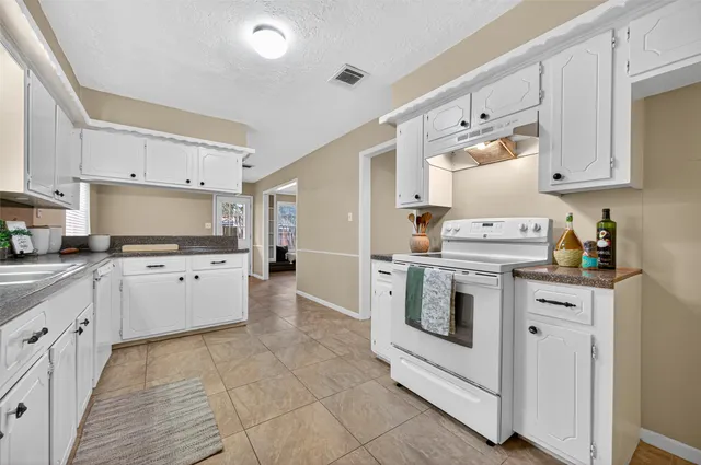 a kitchen with white cabinets and white appliances