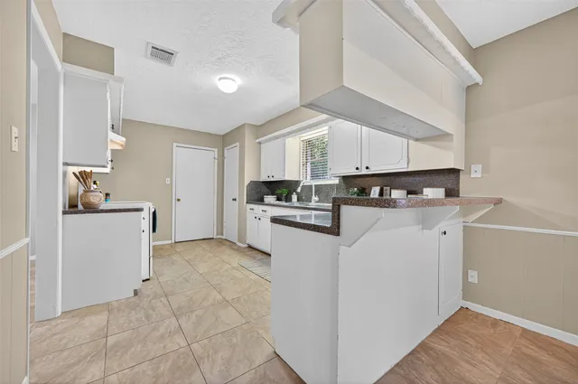 a kitchen with granite countertop white cabinets and white appliances