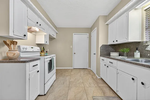 a kitchen with white cabinets and white appliances