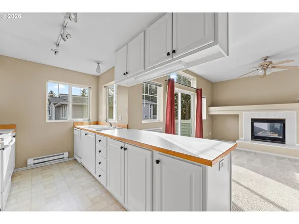 a kitchen with granite countertop a sink and dishwasher a refrigerator with white cabinets