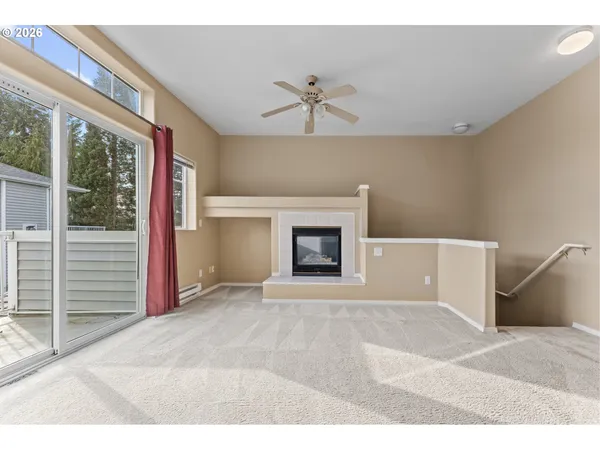 a view of an empty room with a fireplace and a window