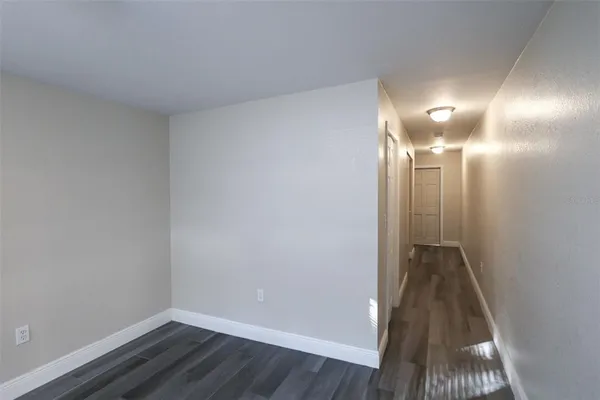 an empty room with wooden floor and window