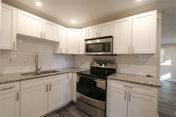 a kitchen with appliances a sink and cabinets