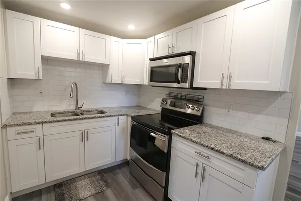 a kitchen with stainless steel appliances granite countertop a refrigerator and a sink