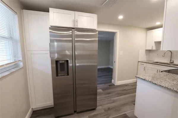 a view of a room with wooden floor and chandelier fan