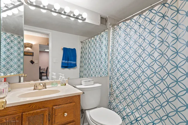 a bathroom with a sink mirror vanity and toilet