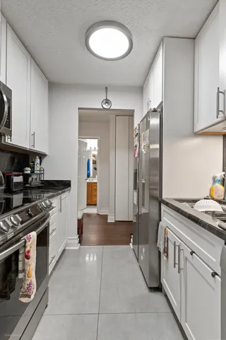 a kitchen with stainless steel appliances granite countertop a stove and a refrigerator