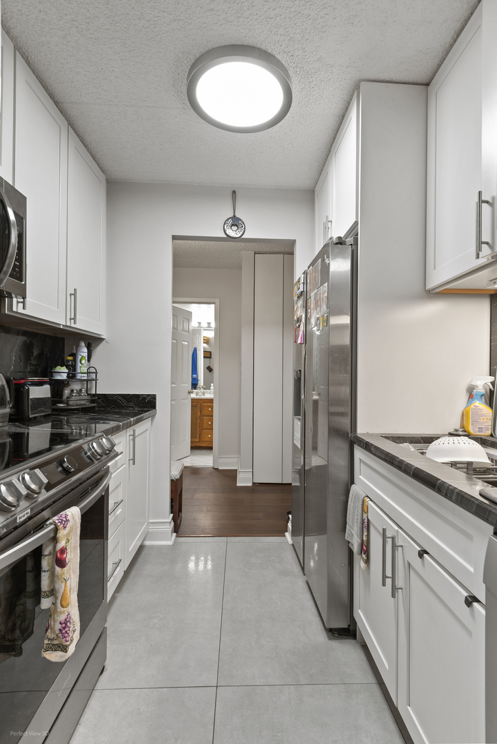 9701 North Dee Road, Unit 5E Niles, IL 60714 - Photo 9 of 18 a kitchen with stainless steel appliances granite countertop a stove and a refrigerator