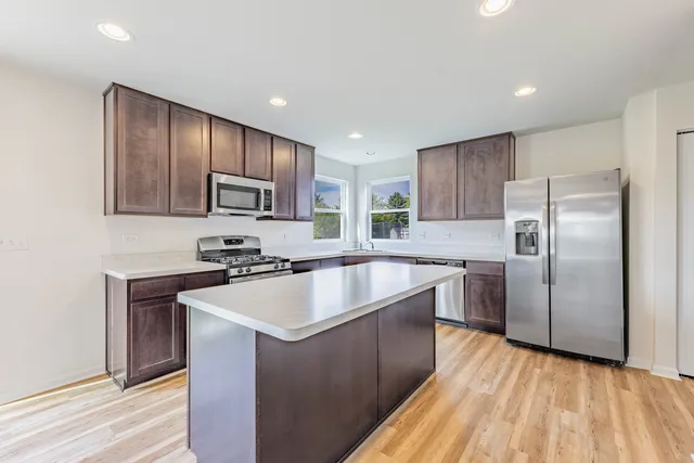 a kitchen with wooden cabinets a sink and stainless steel appliances