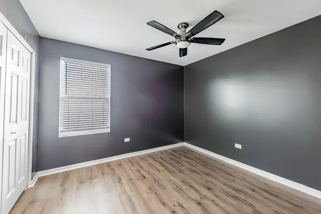 an empty room with a window and a fan