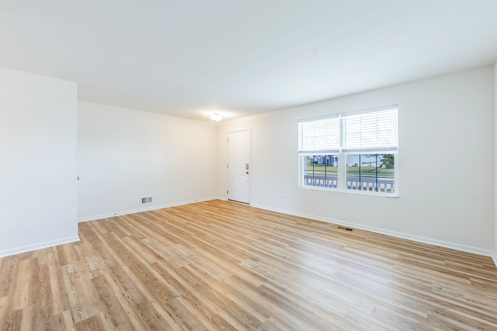 1019 Freeman Street Plano, IL 60545 - Photo 2 of 28 an empty room with wooden floor and windows