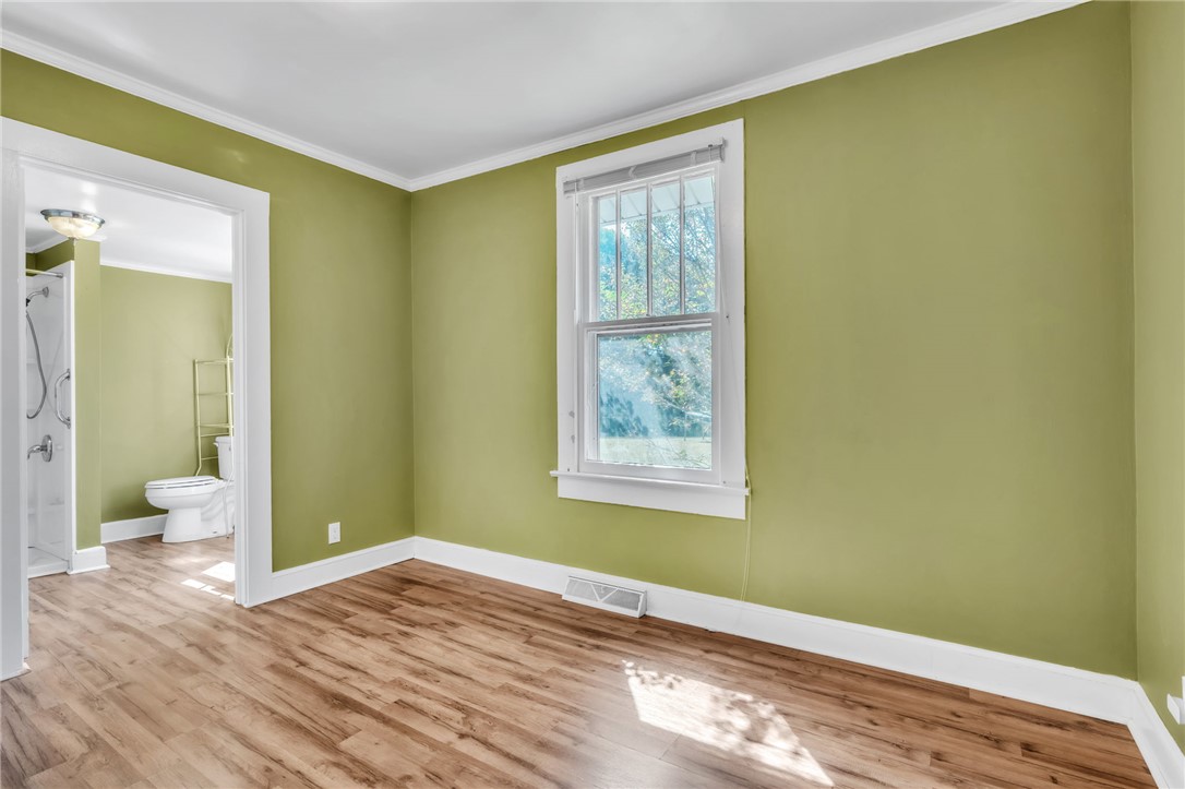 121 Ellison Street Belton, SC 29627 - Photo 16 of 30 Bright room featuring rich hardwood-style flooring, a large window, and direct access to a functional bathroom.