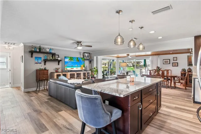 a kitchen with stainless steel appliances granite countertop a sink dishwasher and a stove with wooden floor